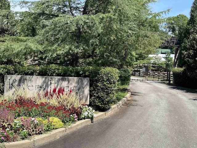 view of road featuring a gate, curbs, and a gated entry