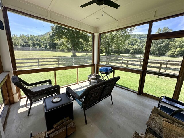 sunroom / solarium featuring a rural view, a healthy amount of sunlight, and ceiling fan