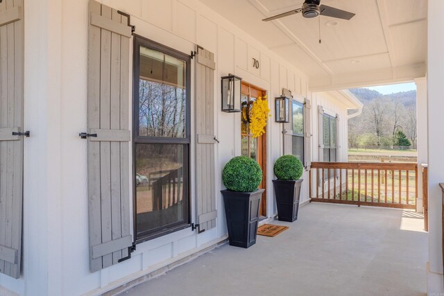 property entrance with a mountain view, covered porch, and ceiling fan