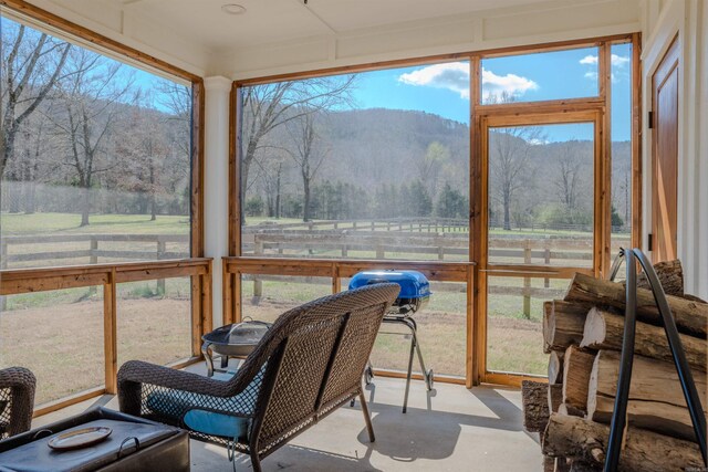 sunroom / solarium with a healthy amount of sunlight and a rural view