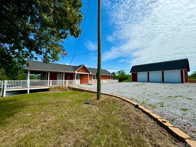 exterior space with a garage, covered porch, and an outbuilding