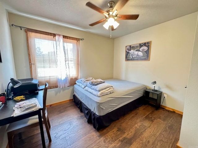 bedroom with dark wood-type flooring, a textured ceiling, and ceiling fan