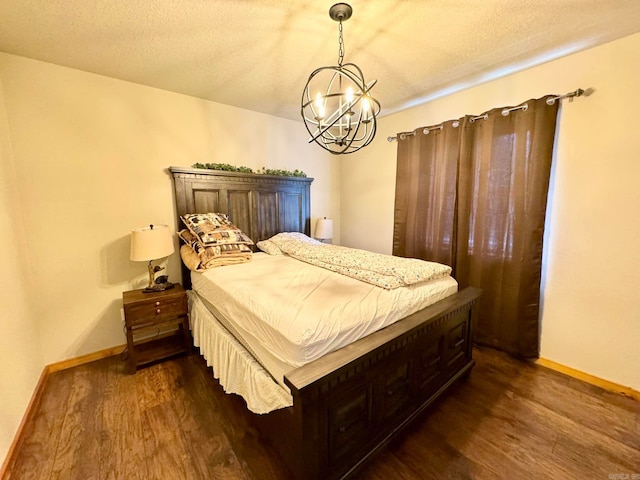 bedroom featuring dark hardwood / wood-style floors, an inviting chandelier, and a textured ceiling