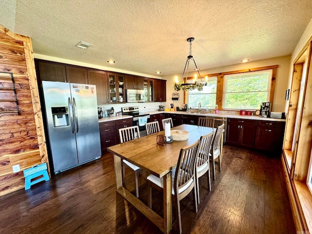 dining space with sink, dark hardwood / wood-style floors, an inviting chandelier, and a textured ceiling