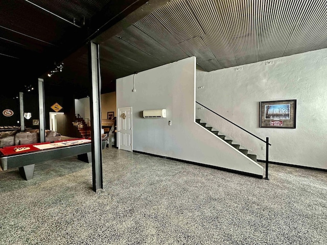 basement featuring billiards, a wall mounted AC, baseboards, stairs, and a textured wall