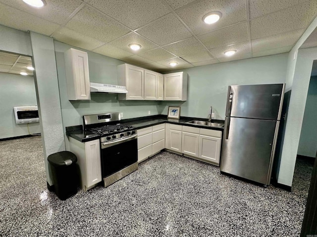 kitchen with heating unit, a sink, stainless steel appliances, under cabinet range hood, and white cabinetry