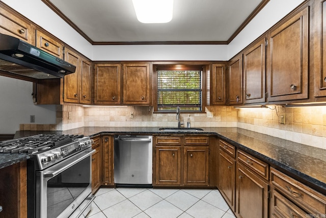 kitchen featuring dark stone countertops, appliances with stainless steel finishes, crown molding, and sink