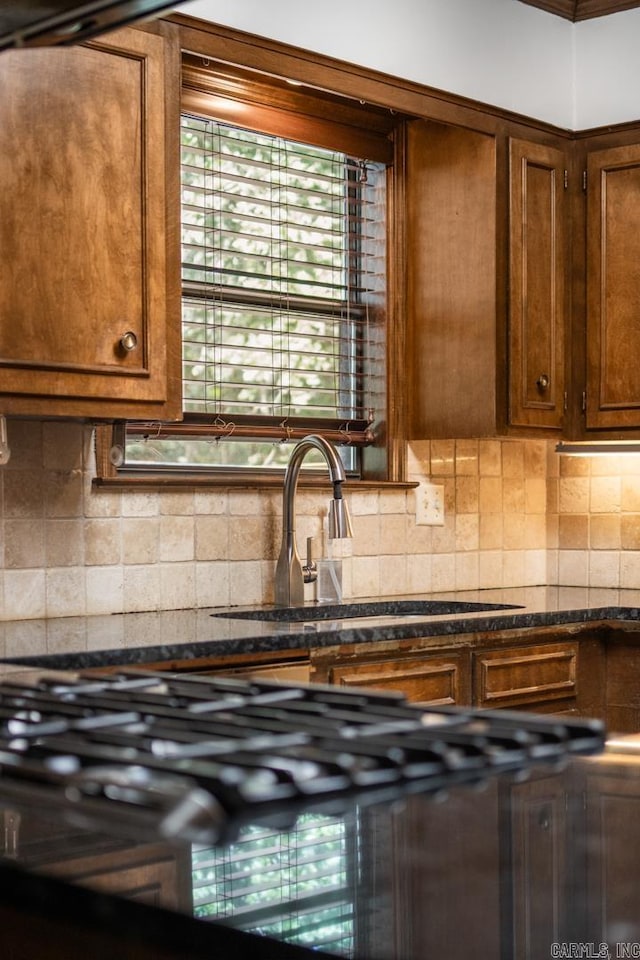 kitchen with sink, backsplash, and dark stone counters