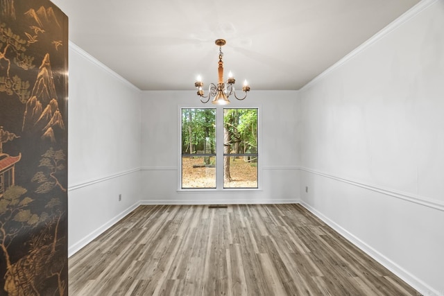 unfurnished dining area featuring ornamental molding, a chandelier, and dark hardwood / wood-style floors