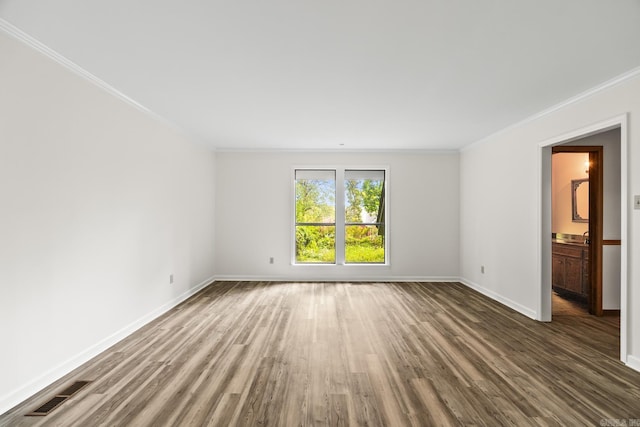 empty room with crown molding and dark hardwood / wood-style flooring