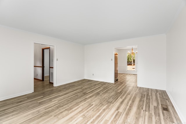 unfurnished room with light wood-type flooring, ornamental molding, and a chandelier