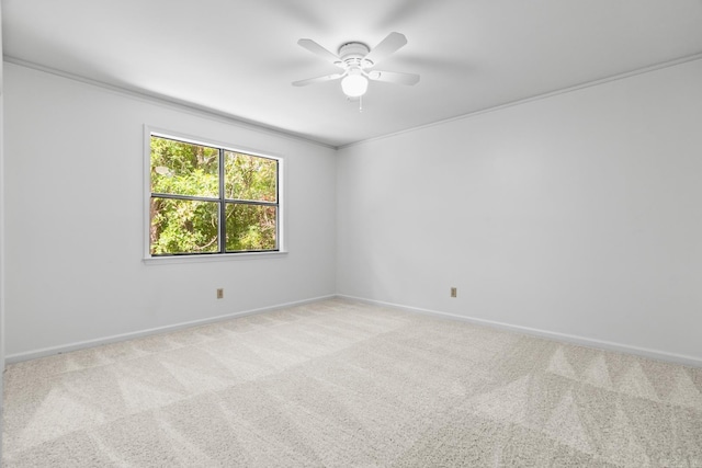 carpeted spare room featuring crown molding and ceiling fan