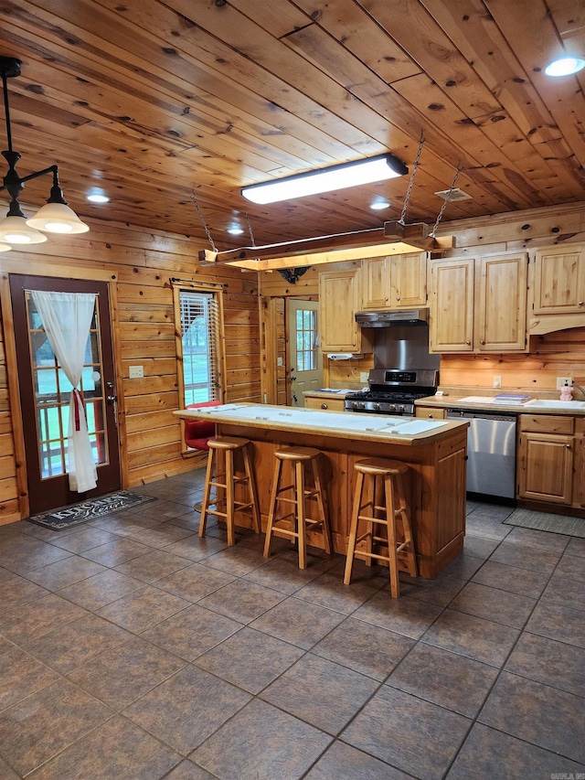 kitchen featuring a center island, wood ceiling, stainless steel appliances, and a kitchen bar