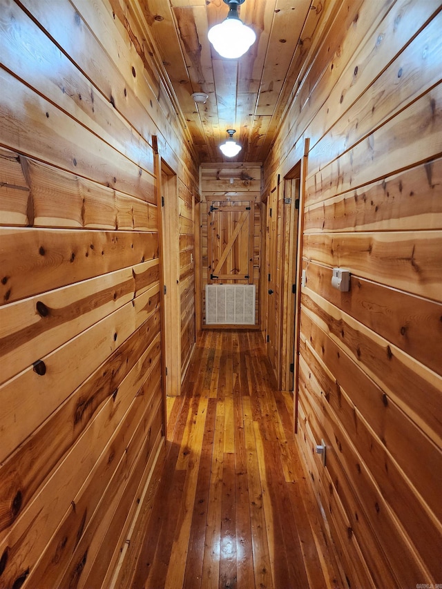 hallway featuring wood ceiling, wood walls, and hardwood / wood-style flooring