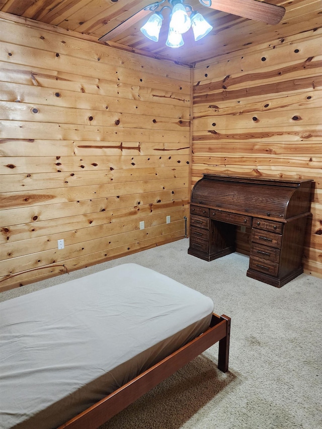 carpeted bedroom with wood ceiling, ceiling fan, and wooden walls