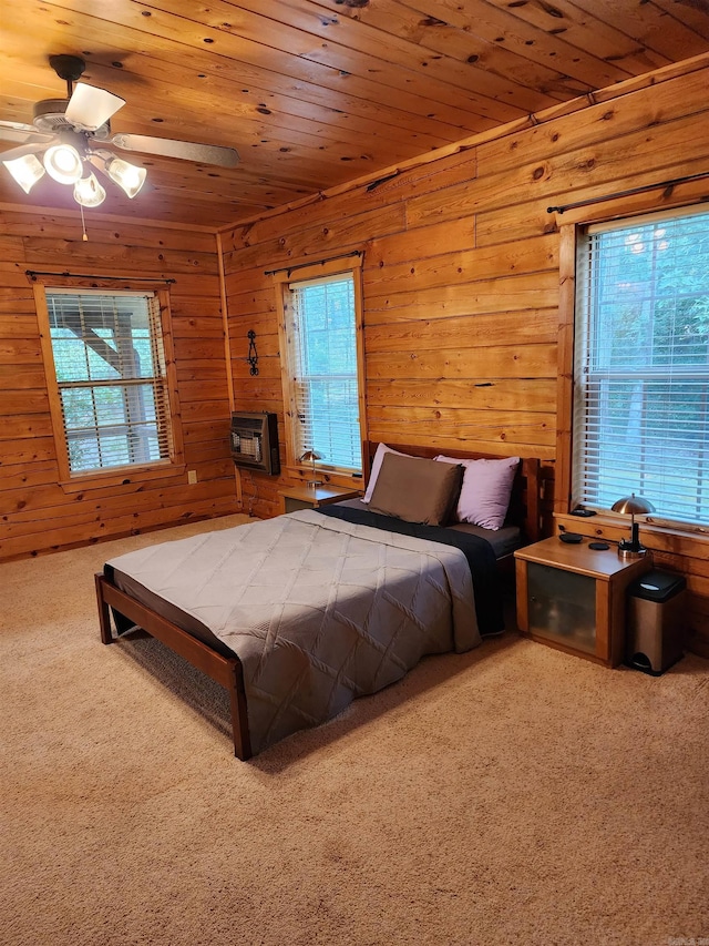 carpeted bedroom with wooden ceiling, wood walls, and ceiling fan