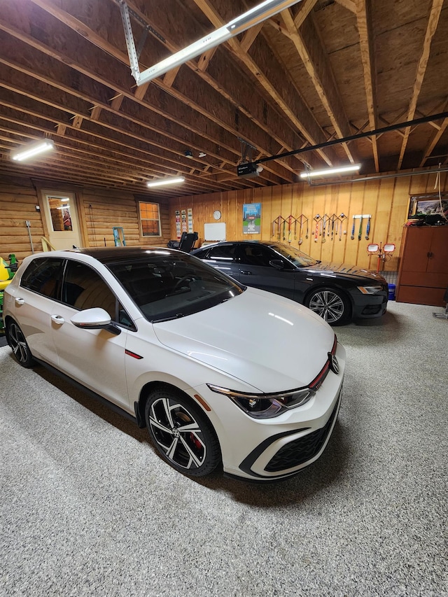 garage with a garage door opener and wooden walls