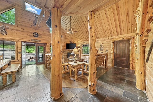 entryway featuring high vaulted ceiling, wooden walls, wooden ceiling, and ceiling fan