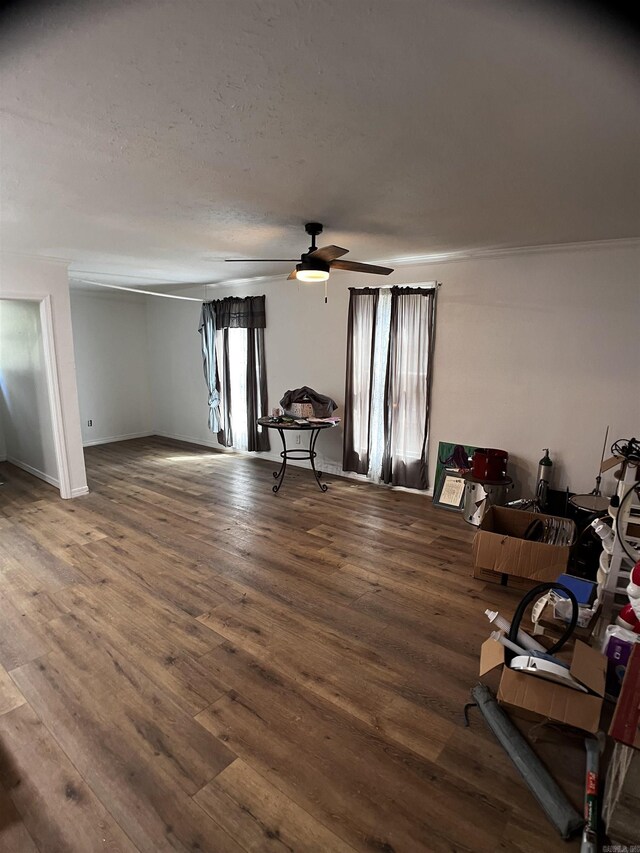 unfurnished living room featuring ceiling fan and hardwood / wood-style floors