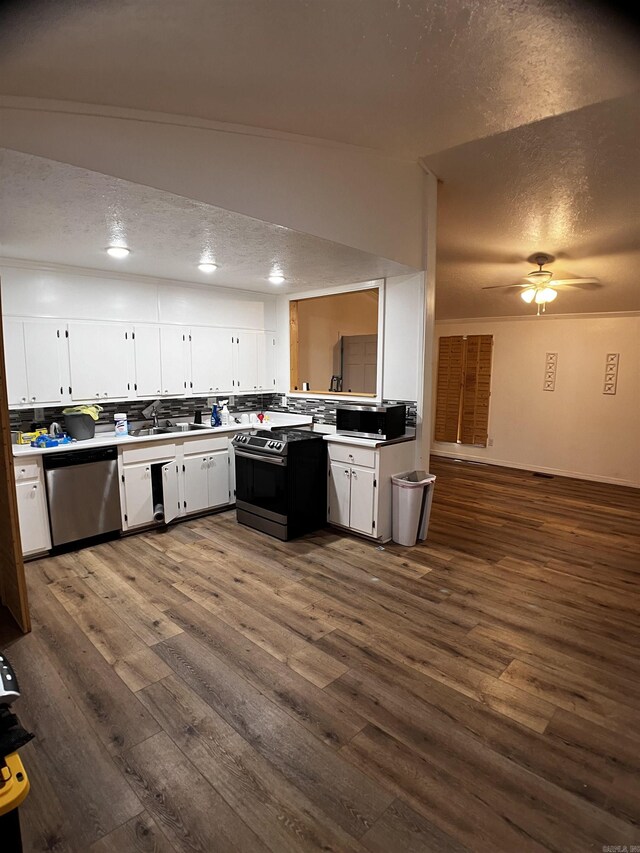 kitchen with dark wood-type flooring, ceiling fan, stainless steel appliances, and white cabinetry