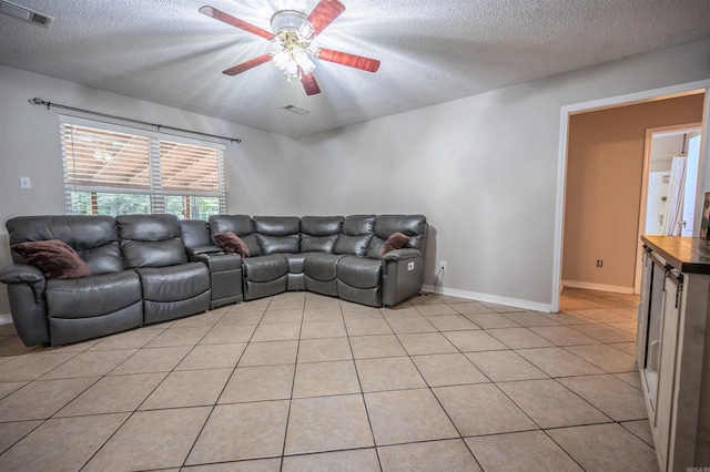 tiled living room with ceiling fan and a textured ceiling