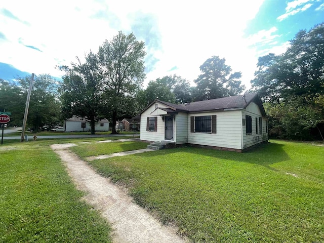 rear view of house featuring a garage and a yard