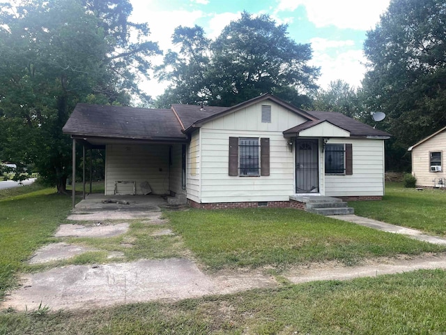 view of front of property with a carport and a front lawn