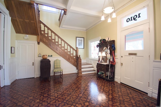 foyer featuring ornamental molding and beamed ceiling