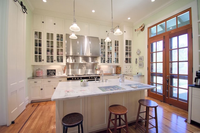 kitchen featuring light wood-type flooring, a kitchen breakfast bar, and a healthy amount of sunlight