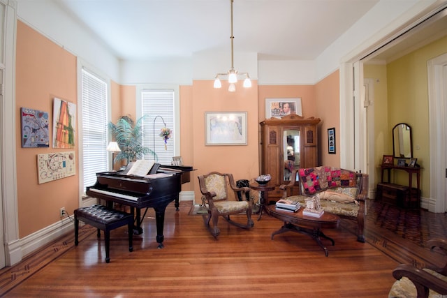 living area with hardwood / wood-style floors and an inviting chandelier