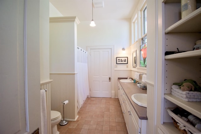 bathroom featuring tile patterned flooring, toilet, walk in shower, and vanity