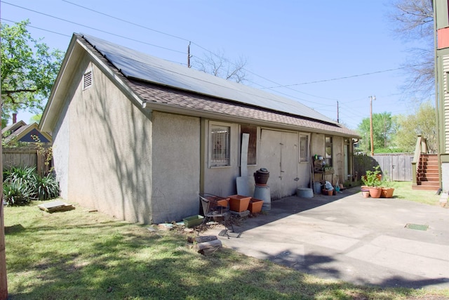 exterior space with a yard, solar panels, and a patio