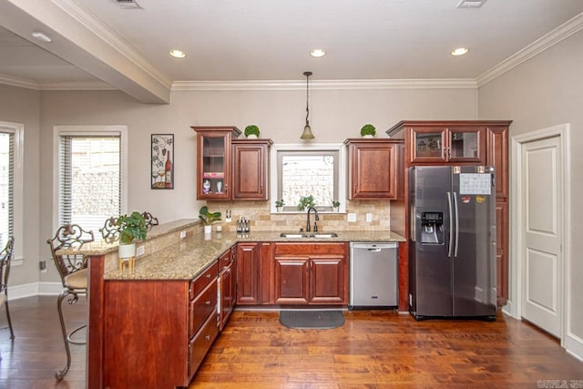 kitchen featuring a kitchen bar, stainless steel appliances, kitchen peninsula, sink, and dark hardwood / wood-style floors