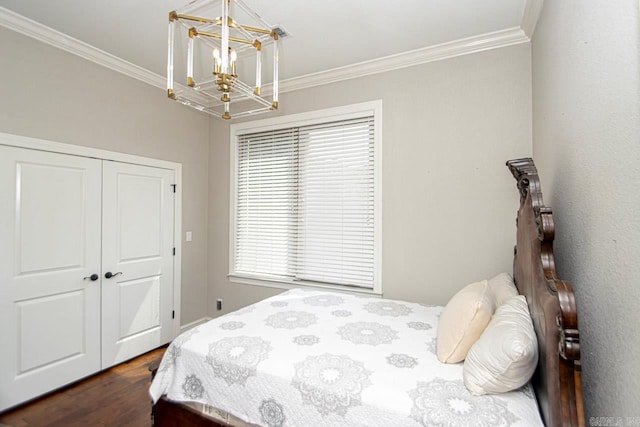 bedroom with crown molding, dark hardwood / wood-style floors, a closet, and a chandelier