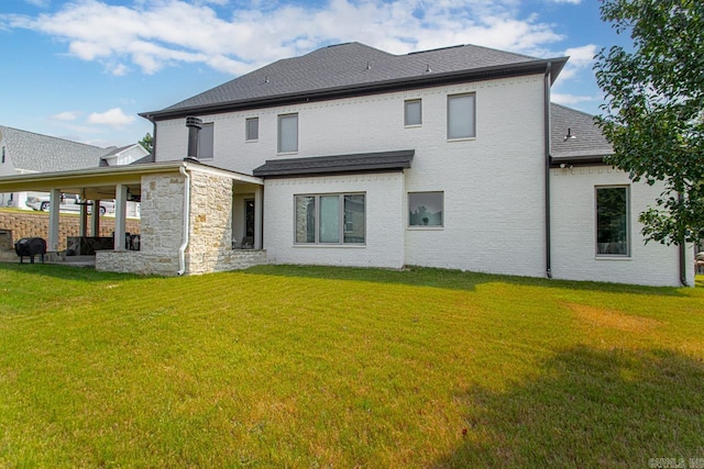 rear view of house featuring a yard and a patio