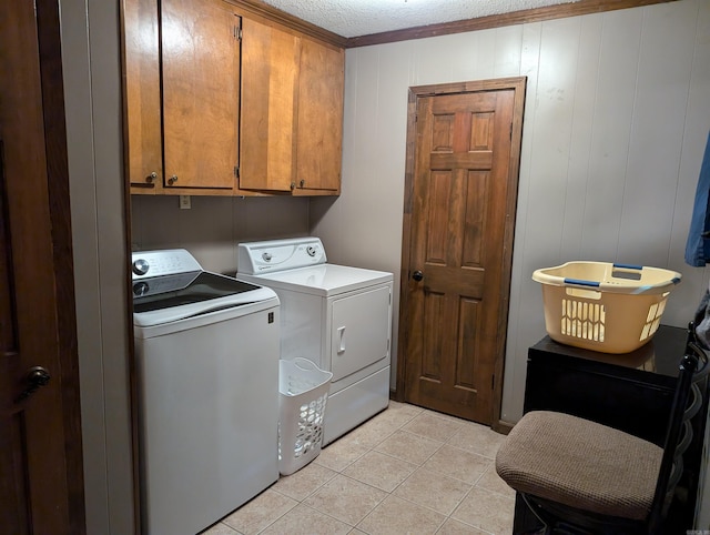 laundry area featuring independent washer and dryer, cabinets, ornamental molding, a textured ceiling, and light tile patterned floors