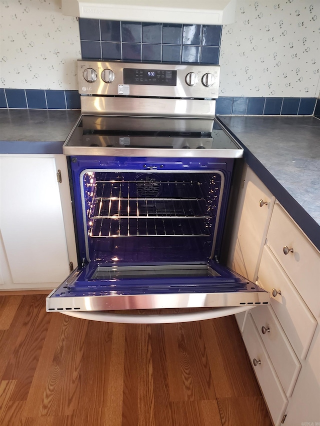 details featuring stainless steel electric range oven and wood-type flooring