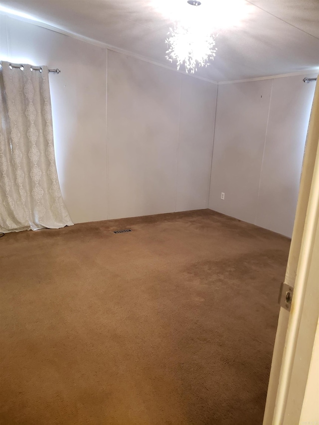carpeted spare room with a notable chandelier