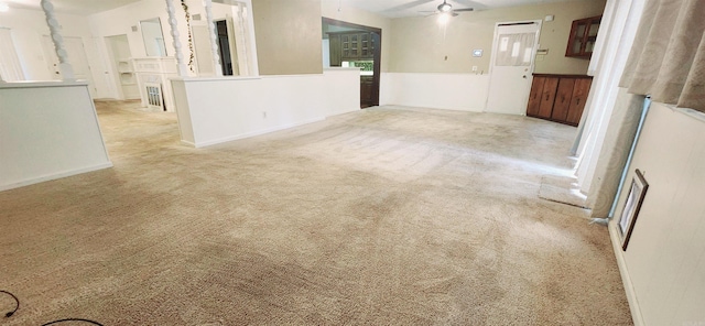 empty room featuring light colored carpet, ceiling fan, and a fireplace