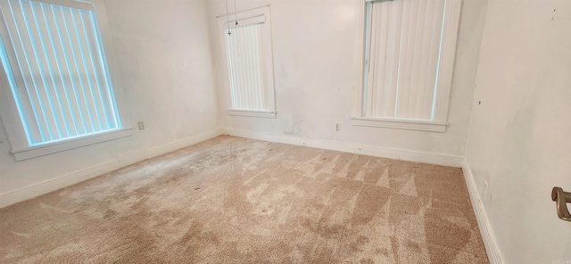 spare room featuring light colored carpet