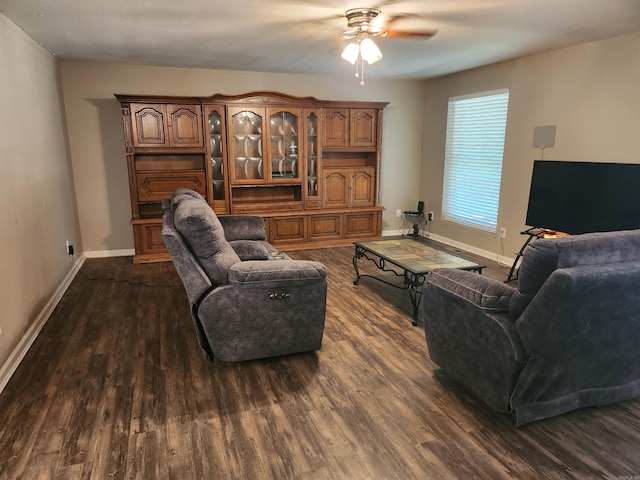 living room featuring dark wood-type flooring and ceiling fan