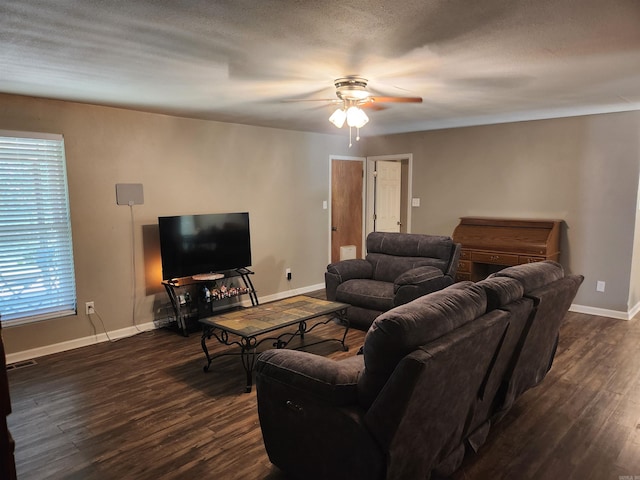 living room with ceiling fan, dark hardwood / wood-style flooring, and a textured ceiling