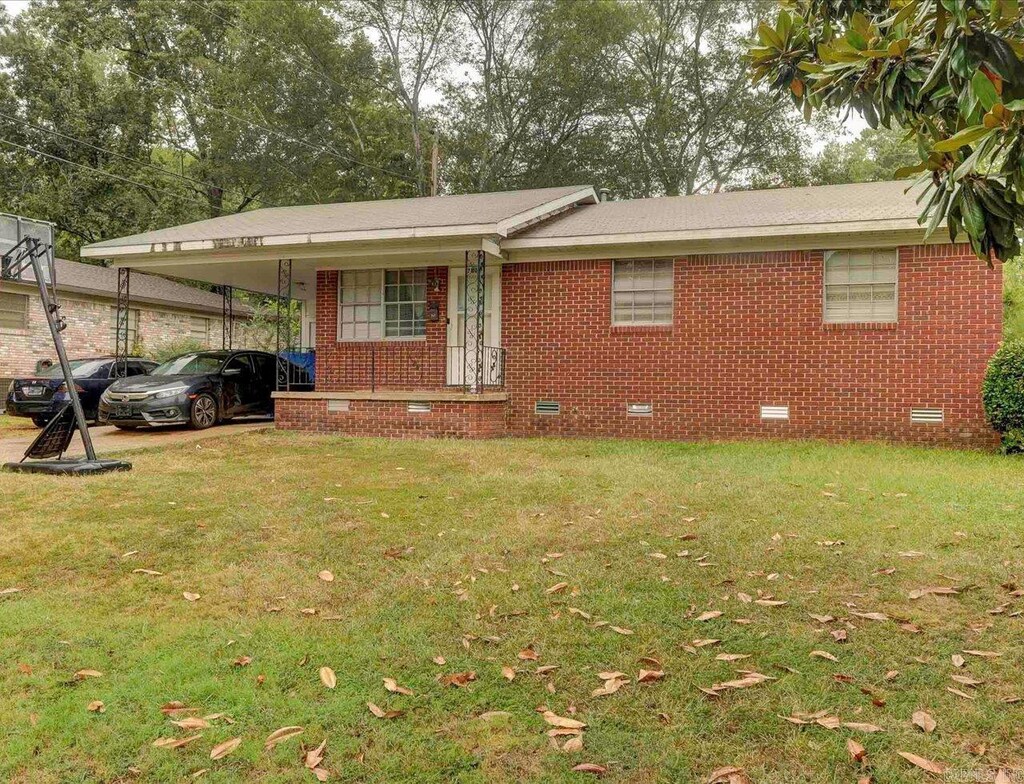 single story home with a front lawn and a carport