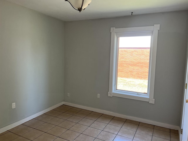 empty room with light tile patterned flooring and baseboards