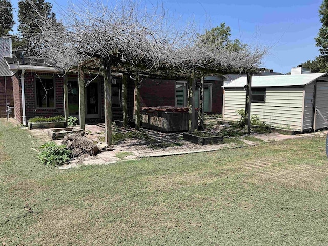 back of property with brick siding, a garden, a hot tub, and a lawn