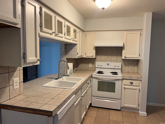 kitchen featuring tile countertops, sink, white range with electric stovetop, light tile patterned flooring, and stainless steel dishwasher