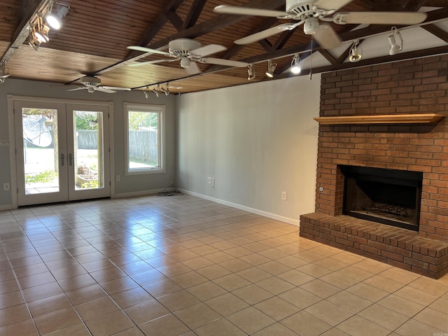 unfurnished living room featuring baseboards, tile patterned floors, a fireplace, beamed ceiling, and wood ceiling