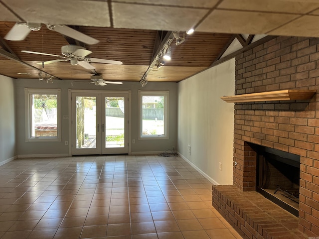 unfurnished living room featuring a fireplace, a ceiling fan, wooden ceiling, tile patterned floors, and french doors