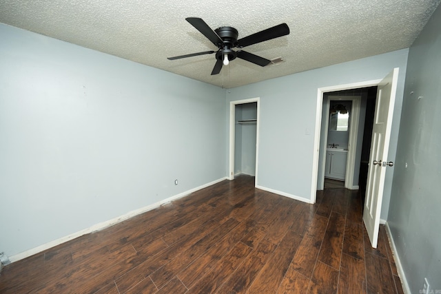 unfurnished bedroom with a textured ceiling, ceiling fan, dark hardwood / wood-style floors, and a closet