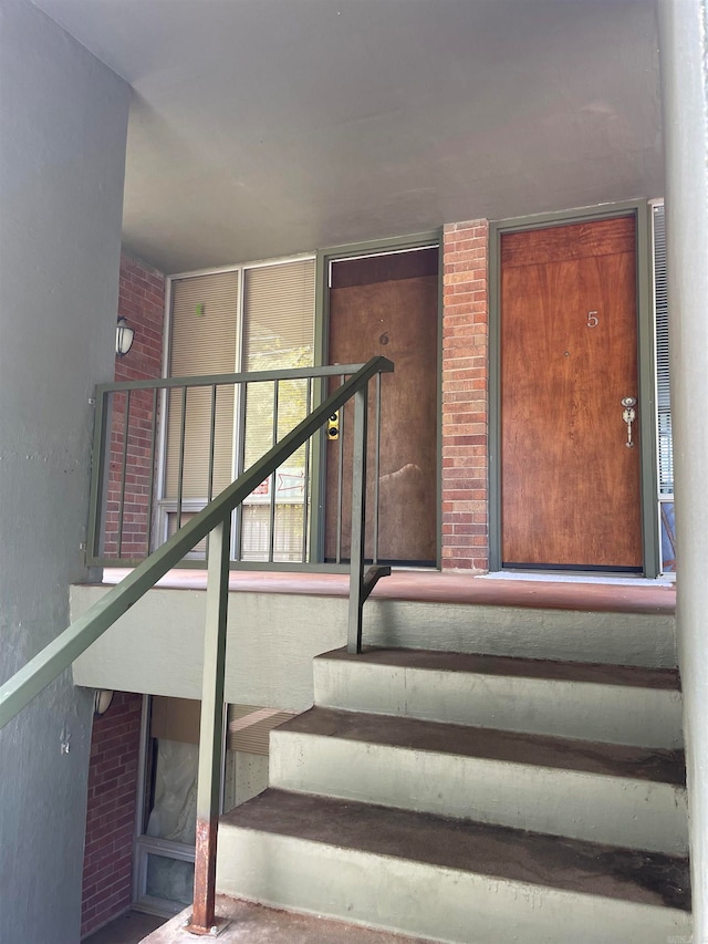 stairway featuring brick wall